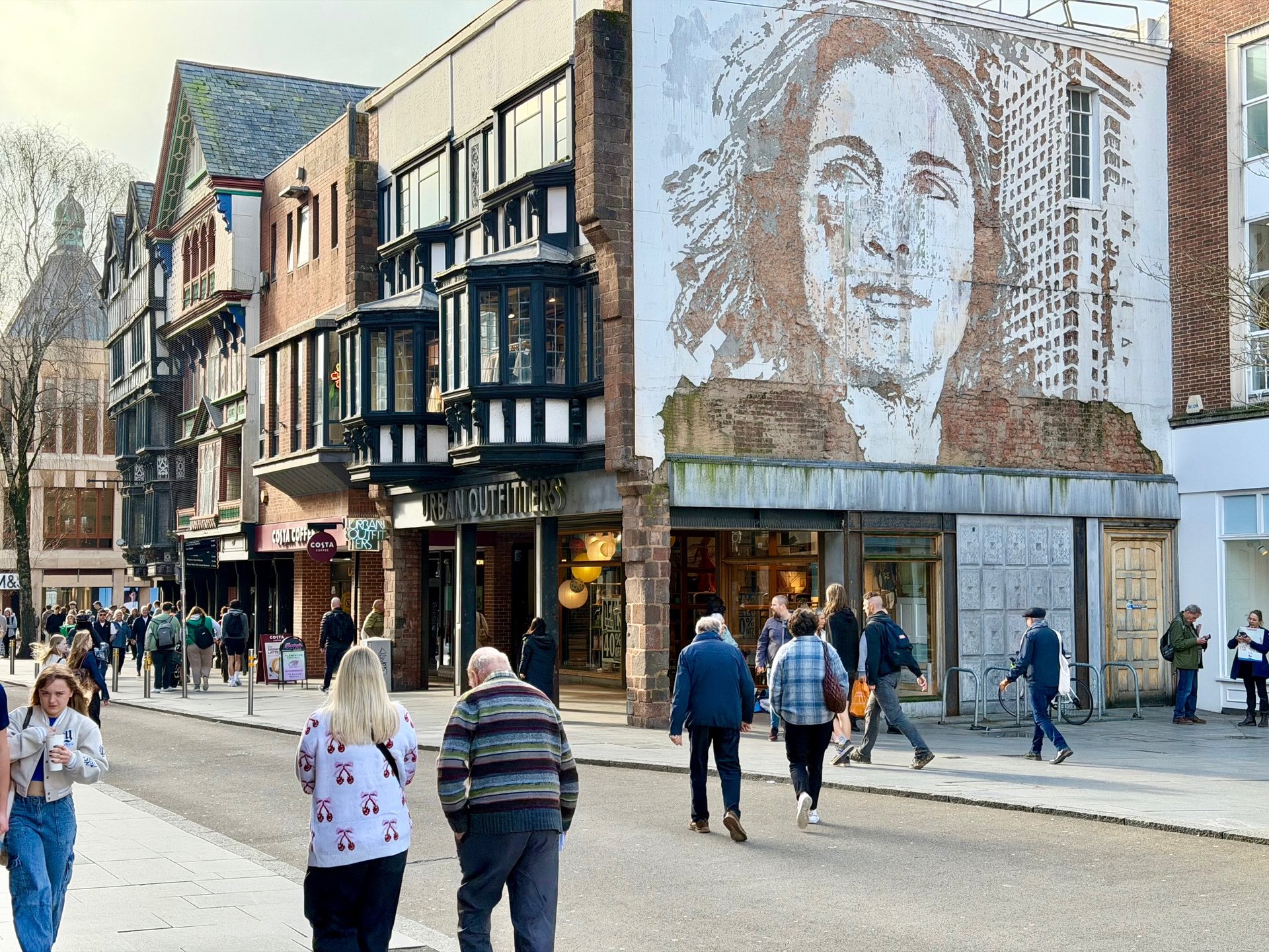Exeter High Street showing mural of a face carved into brick wall